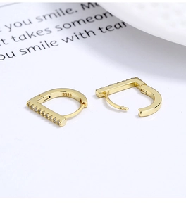 Macro view of gold S925 silver D-shaped hoop earrings with clear sparkling zircons
