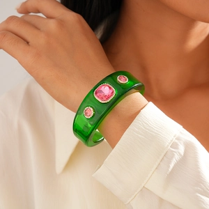 Detail of green resin bangle featuring pink square stones and white zircon accents