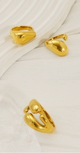 Detailed view of gold irregular liquid metal drip ring on silk and ice glass textures