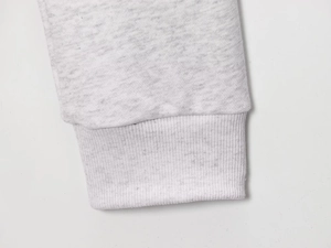 Detailed macro shot of light grey knitted sweater sleeve with ribbed cuffs and texture