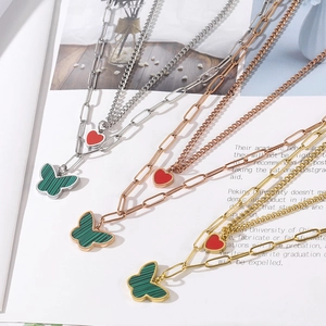 Detailed view of layered butterfly and heart necklaces in silver, rose gold, and gold