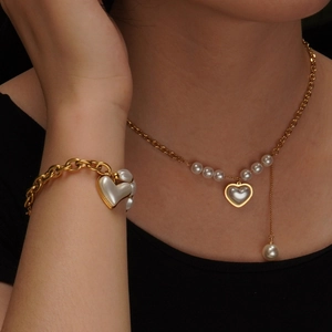 Elegant gold necklace and bracelet set with irregular pearls and heart charm