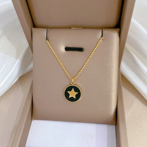Collier minimaliste en titane doré avec pendentif étoile noire dans un écrin