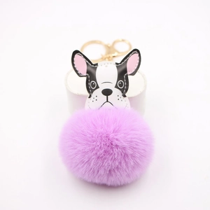 Detail of French Bulldog plush keychain with purple pompom and gold metal clasp