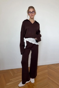 Detail eines dunkelbraunen Stricksets mit Polokragen-Pullover und weiter Hose