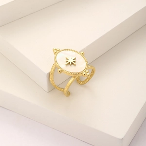 Detail of vintage oval shell ring in gold finish with star emblem on textured band
