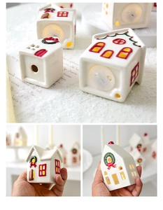 Detail of a ceramic Christmas house candle holder showing bottom battery compartment and LED