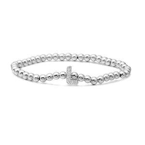 Macro detail of silver-beaded elastic bracelet featuring a micro-paved zircon letter L charm