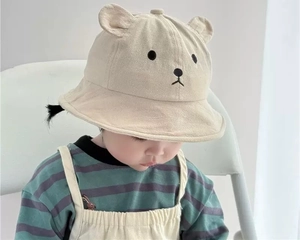 Close-up of cute bear ear details and embroidery on this beige baby sun hat