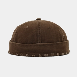 Détail du bonnet docker marron vieilli avec bords effilochés et texture en toile de coton