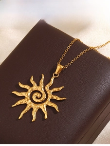 Detailed macro shot of golden sun pendant with hammered texture on brown leather jewelry box
