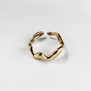 Detailed close-up of a golden irregular wavy open ring made of polished stainless steel