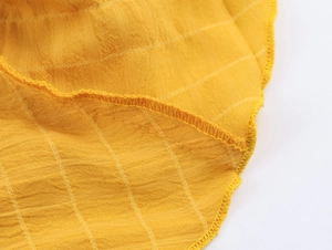 Dettaglio ravvicinato di tessuto giallo in cotone e lino con trama a righe e cucitura piatta