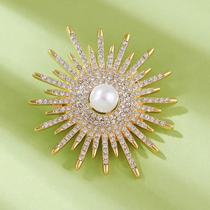 Macro detail of sunburst pearl brooch featuring gold plating and shimmering rhinestones