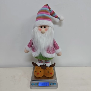Close-up of a colorful telescopic Christmas gnome doll being weighed on a scale
