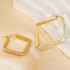 Detailed macro of gold square earrings featuring sparkling pavé zircon gemstones