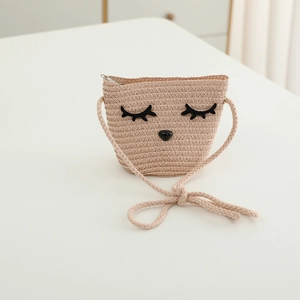 Dettaglio della borsa a tracolla in paglia beige con ricamo di animali e naso a cuore