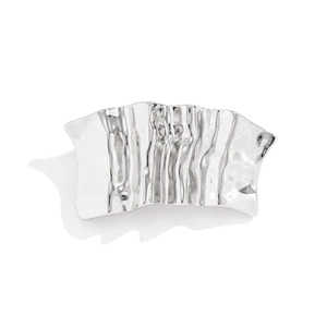 Detail of silver irregular wavy textured metal hair clip with a polished liquid finish