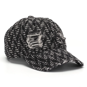 Close-up of distressed tweed texture and frayed hole details on a baseball cap