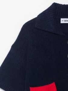 Detailed macro view of navy blue knit sweater collar with contrasting red pocket accent
