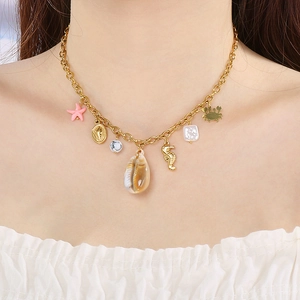 Collier doré thème océan avec pendentifs étoile de mer et hippocampe sur une femme