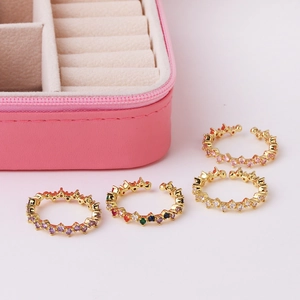 Detail of adjustable gold-plated rings with multi-colored cubic zirconia in a jewelry box