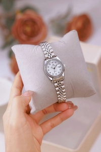 Macro shot of silver steel watch with crystal bezel and mother-of-pearl date dial