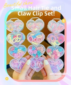 Detail of heart-shaped gift box containing colorful flower clips and elastic hair bands
