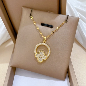 Detailed shot of golden clover pendant with crystals in a luxury jewelry box