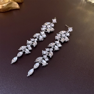 Detail of silver tassel earrings with leaf pattern and waterdrop clear crystals