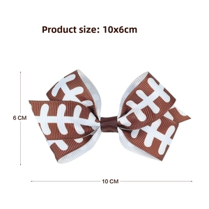 Detail showing the 10x6cm football pattern bow hair clip with grosgrain texture and metal clip