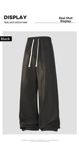 Detail of black wide-leg joggers featuring elastic waist and white drawstring closure