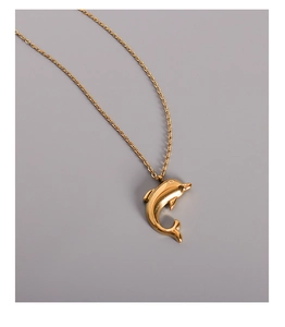Detailed close-up of 18k gold plated dolphin pendant with a polished metallic finish