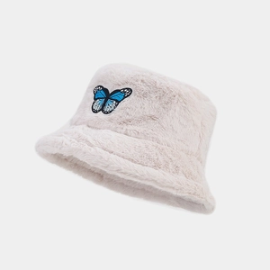 Close-up of the plush cream-colored bucket hat showing detailed blue butterfly embroidery