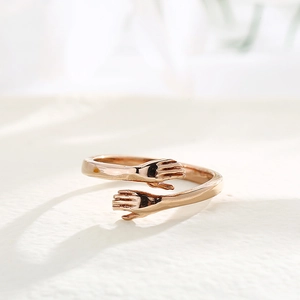 Detailed close-up of a minimalist rose gold hug ring featuring an open band design