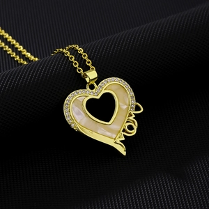 Close-up of gold heart pendant necklace with MOM lettering and zircon stones