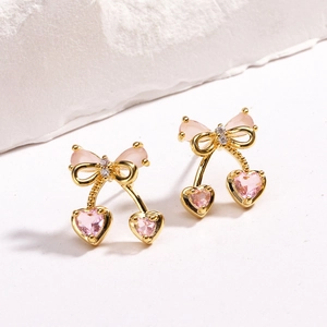 Dettaglio di orecchini a ciliegia placcati oro 18K con cristalli rosa a cuore e fiocco