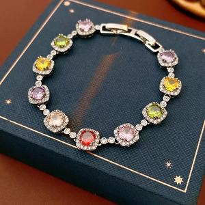 Macro shot of silver tennis bracelet with colorful square zircons in halo settings