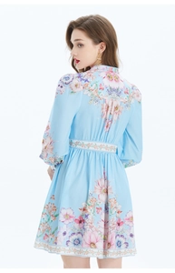 Détail de l'imprimé floral et des manches lanternes au dos de la robe en lin bleu