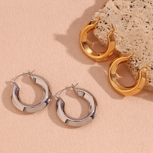 Dettaglio di spessi orecchini a cerchio in acciaio inossidabile placcato oro 18K e argento