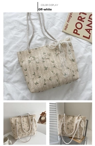 Detail of straw tote bag featuring green leaf embroidery and white lace bow decoration