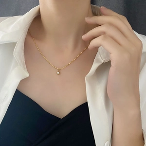 Minimalist titanium steel gold necklace featuring a classic white pearl pendant on a model