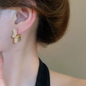 Detailed close-up of gold-plated star hoop earrings with micro-paved cubic zirconia stones