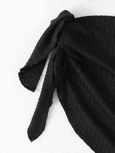 Macro shot of black mesh fabric with wavy texture and hollow details on a three-piece bikini