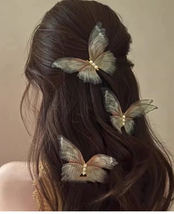 Detail of three tulle butterfly hair clips with pearls and gradient green wings