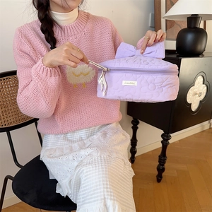 Vue détaillée de la trousse de maquillage matelassée lavande avec broderies et nœud décoratif