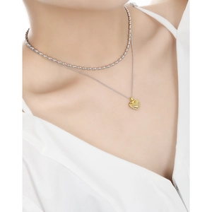 Double-layered S925 silver necklace with gold striped heart pendant on model