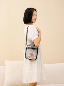 Detailed side view of a clear PVC crossbody bag with black trim and makeup storage