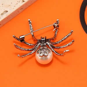 Macro shot of the vintage silver metal spider brooch with white pearl abdomen and pin back