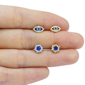 Vue détaillée de clous de nez dorés et argentés avec zircon bleu et motif œil protecteur